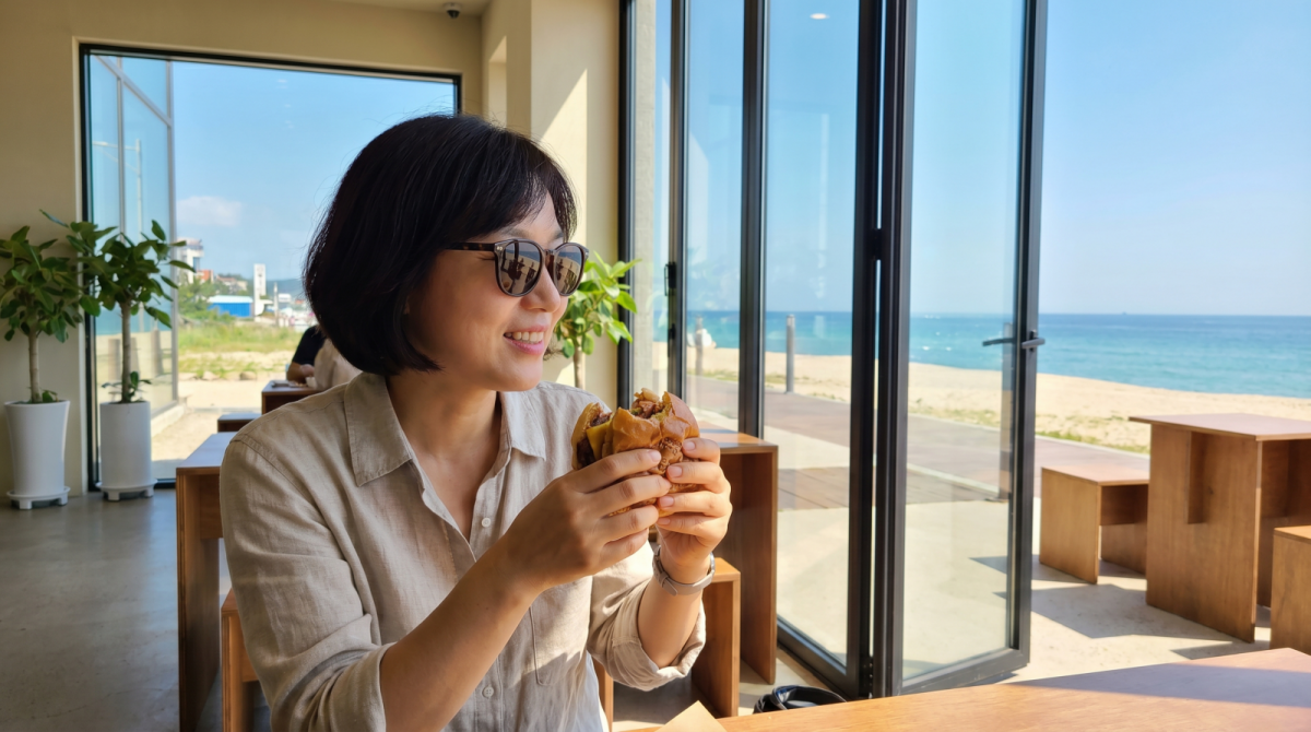 강릉 해변의 버거집에서 바다를 보며 식사를 즐기는 여행객